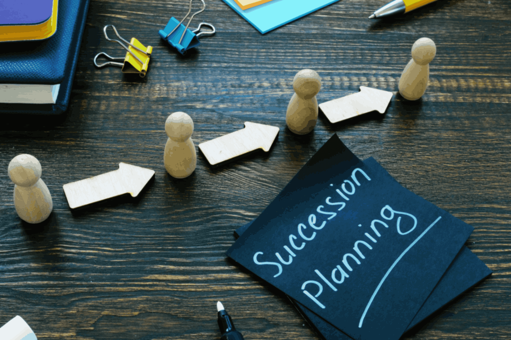 Wooden figures and arrows, succession planning concept.