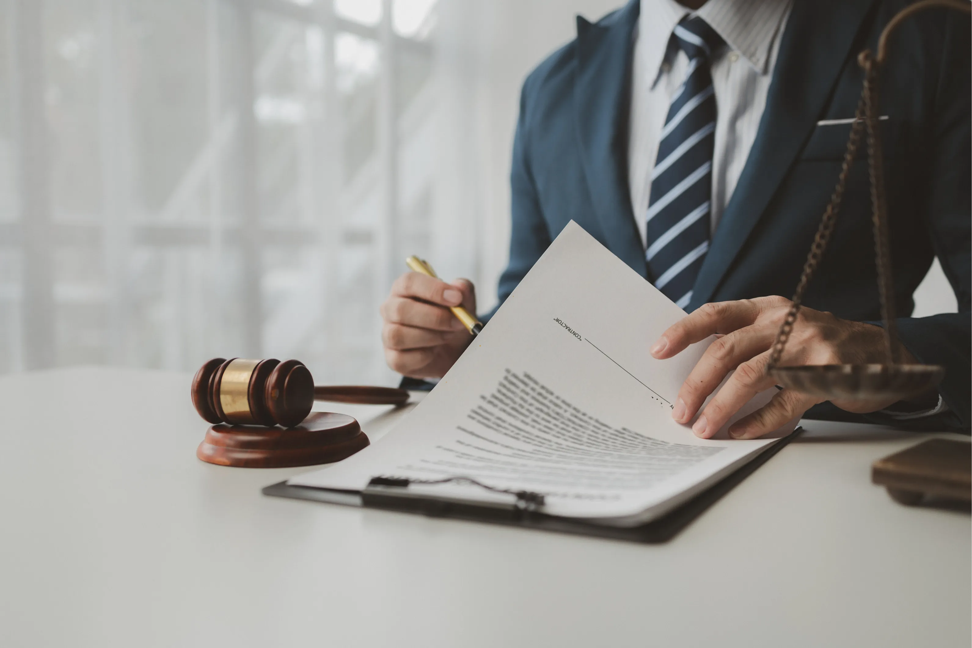 Lawyer reviewing documents beside a gavel.