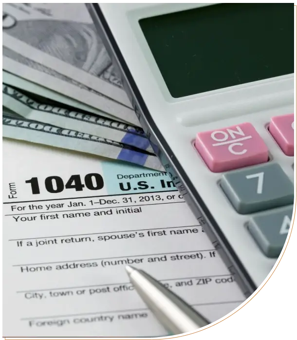 Tax form 1040 with calculator and pen on a desk.