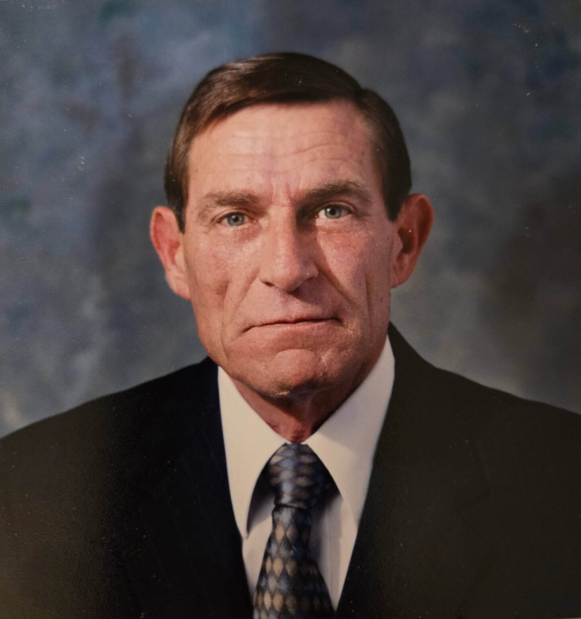 Formal portrait of an older man in a suit and tie.